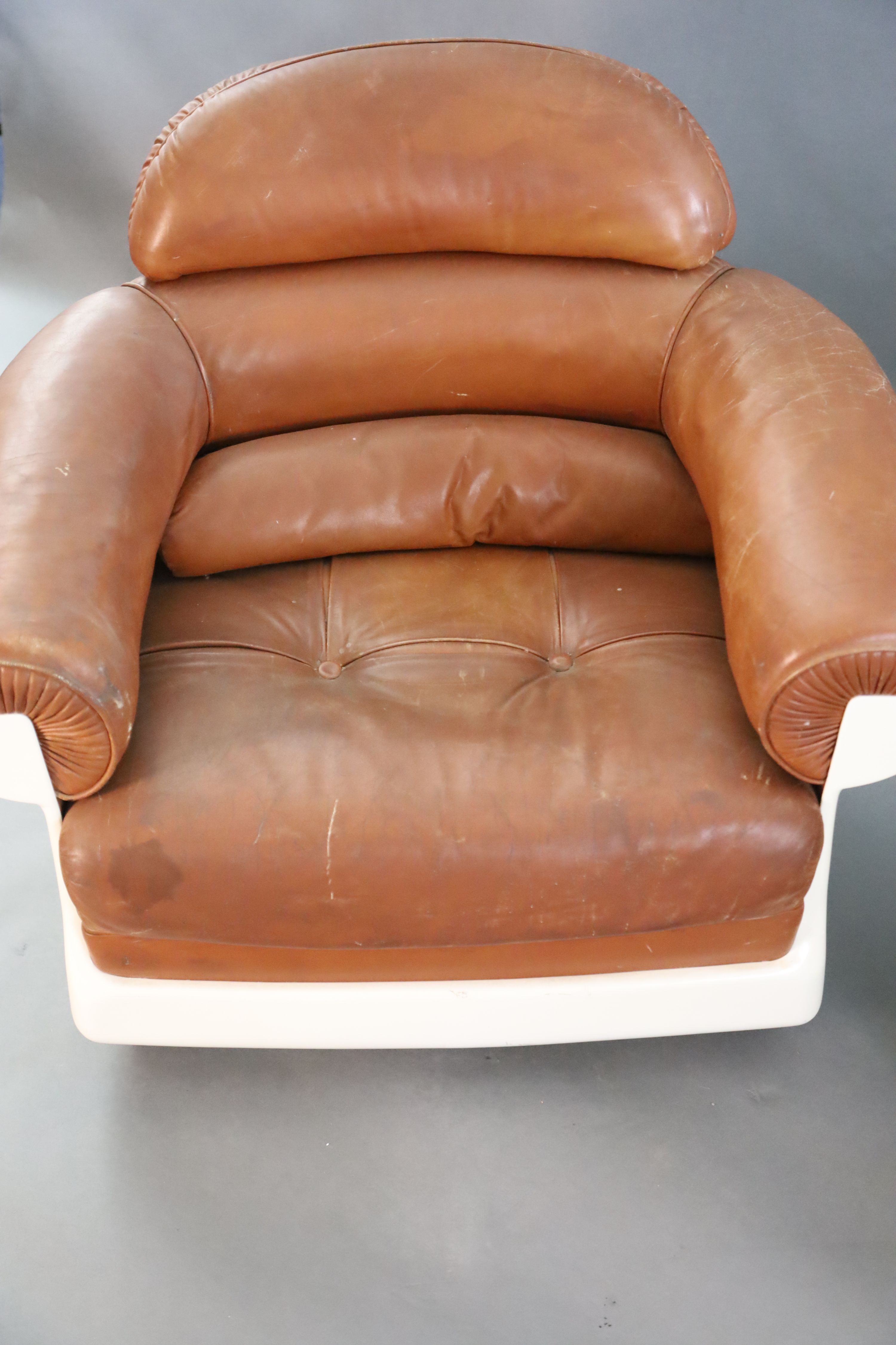 A pair of mid century tan leather and fibreglass tub chairs, possibly French, by Airbourne, W.3ft 1in. D.2ft 7in. H.2ft 8in.